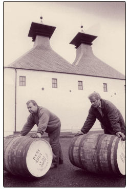 Two men pushing barrels at the Ardbeg Distillery on Islay